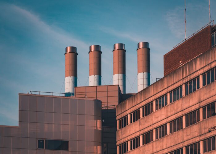 four industrial chimneys on top of a modern building