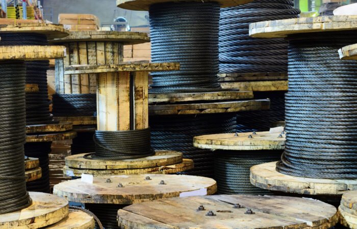 Large cable reels stocked in the factory premises. Workshop production of cable slings.